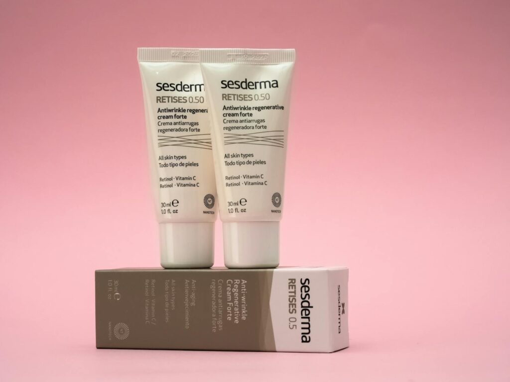 Two Sesderma Retises antiwrinkle creams on a pink background, emphasizing skincare.